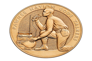 Eine Goldmünze mit der Aufschrift "Pawnee Nation Code Talkers" und einem Bild einer Person mit einem Telefon und einer Box.