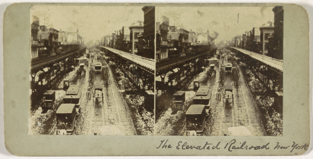 Schwarzes und weißes Foto eines Zuges auf einer erhöhten Eisenbahnstrecke in New York City mit mehreren Fahrzeugen auf den Schienen, Menschen und Gebäuden im Hintergrund und Text unten.