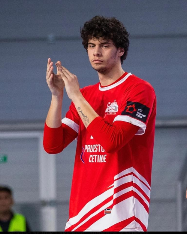 Ein Mann in rot-weißem Shirt klatscht in der Vordergrund mit einer anderen Person und einer Wand im Hintergrund, mit Text 'Kopenhagen Futsal Club - Foto 1' unten.