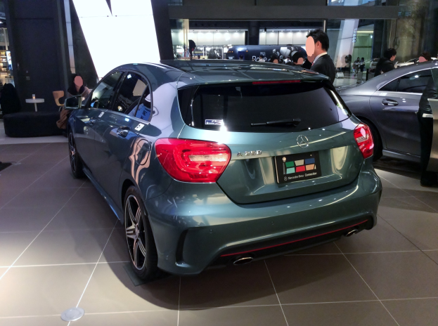 Ein Mercedes-Benz A-Klasse Hatchback mit glänzender schwarzer Lackierung und Chromakzenten wird auf der IAA in Frankfurt umgeben von einer Gruppe von Menschen gezeigt.
