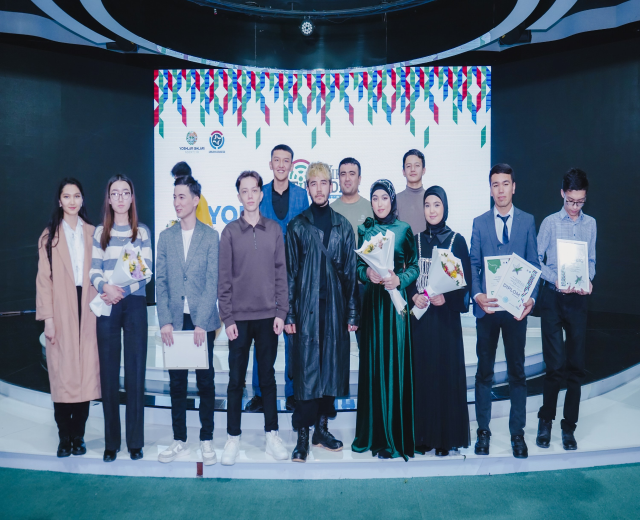 Gruppe von Menschen auf einer Bühne mit Blumensträußen und Urkunden, vor einem Hintergrund mit der Aufschrift "Youth Solar Awards 2019".