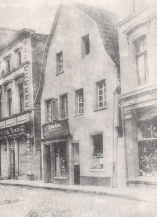 Schwarz-weiß-Bild einer Stra├če mit Geb├Ąuden, die Fenster und Schilder zeigen, und einer Stra├če unten.