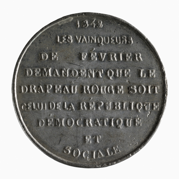 Eine silberne Medaille mit der Inschrift "Demokratische und Soziale" vor einem weißen Hintergrund.