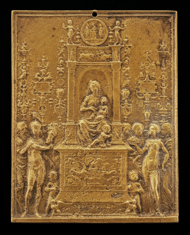 Goldene Plakette mit detaillierter Skulptur einer Frau in einem langen Kleid und einem Mann in einem Anzug und Krawatte auf schwarzem Hintergrund, umrahmt von einem goldenen Rand.