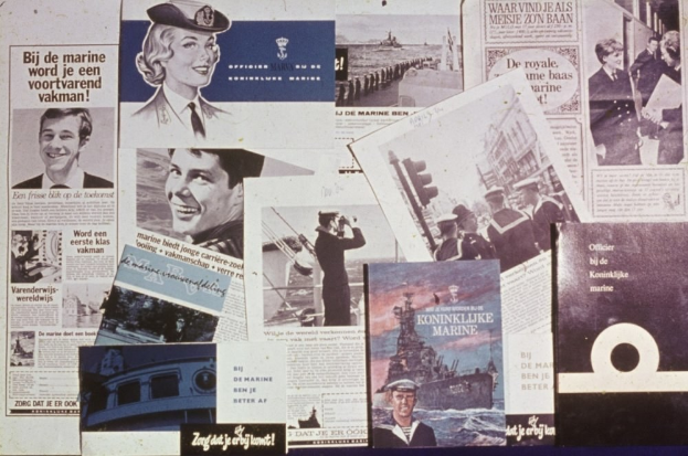 Zeitungen auf einem Tisch mit Bildern eines grinsenden Mannes und einer ernsten Frau mit kurzem dunklen Haar, beide in legerer Kleidung.