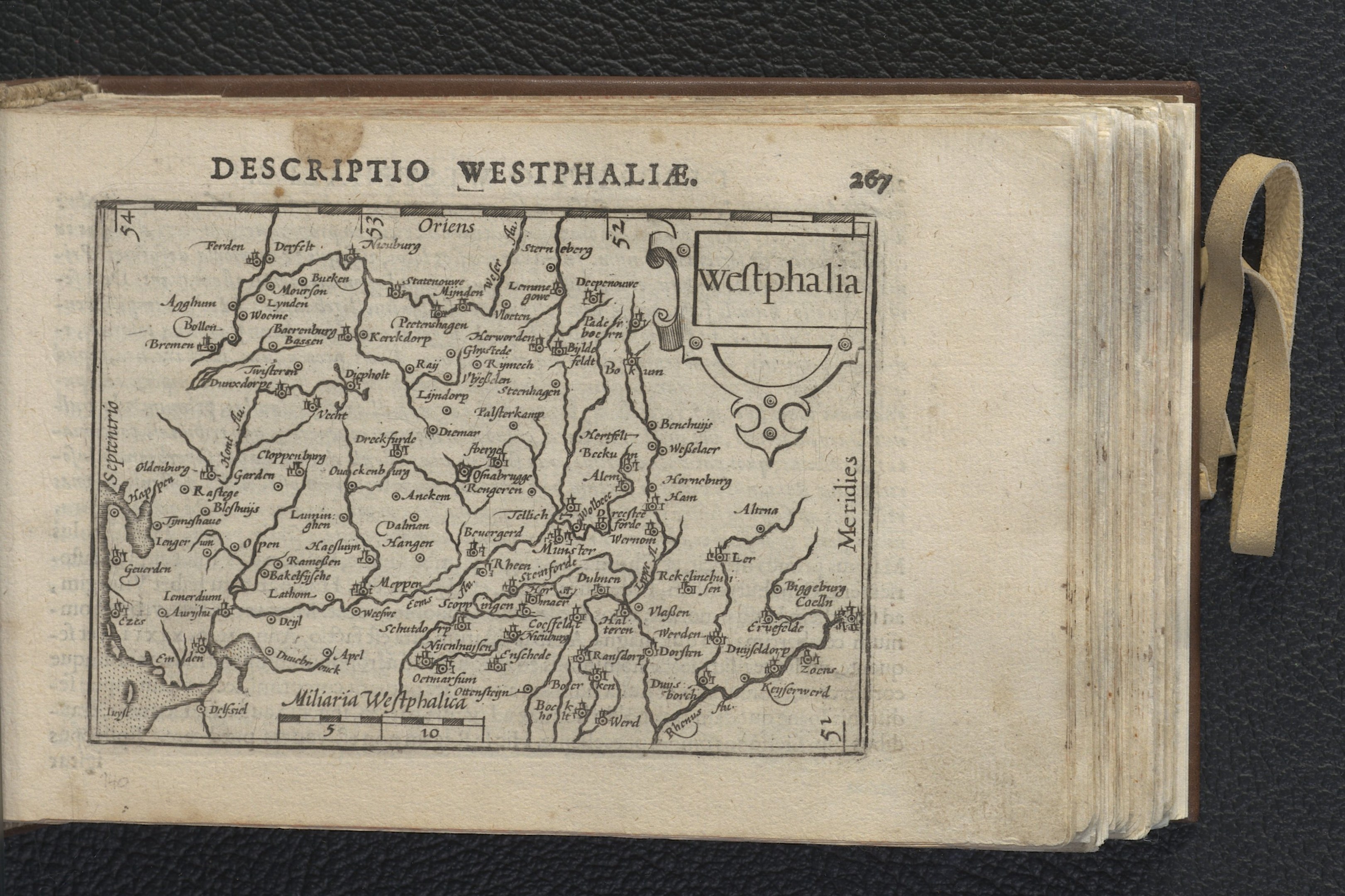 Offenes Buch mit einer detaillierten Karte von Westfalen auf seinen Seiten, das auf einer schwarzen Oberfläche ruht.