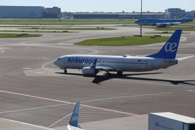 Air Europa Airbus A320-200 auf der Rollbahn am Frankfurter Flughafen mit umliegender Wiese, Pfählen, Gebäuden, Bäumen und einem klaren blauen Himmel.