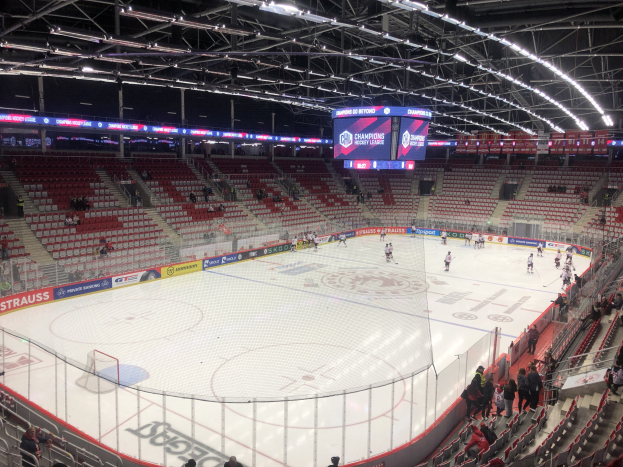 Eishockeyspiel in einer großen Arena zwischen den St. Louis Blues und den Detroit Red Wings, mit Zuschauern auf Sitzen und Stehen in der Nähe der Eisfläche.