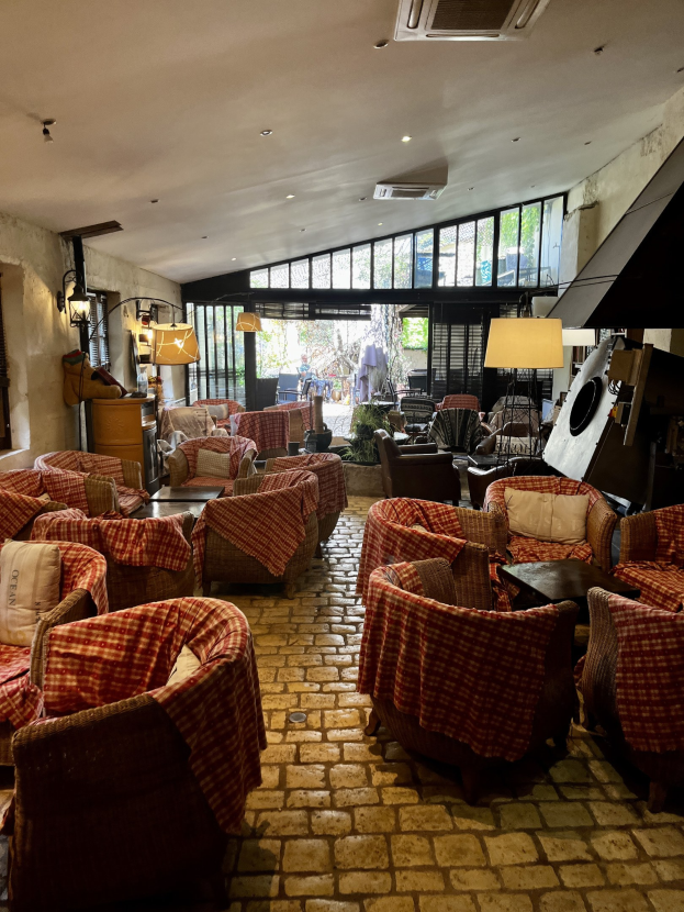 Rezeption des Rathauses mit Stuhlreihen, Tischen, gepolsterten Sofas, wandmontierten Lampen, Deckenklimaanlage und Glasfenstern im Hintergrund.