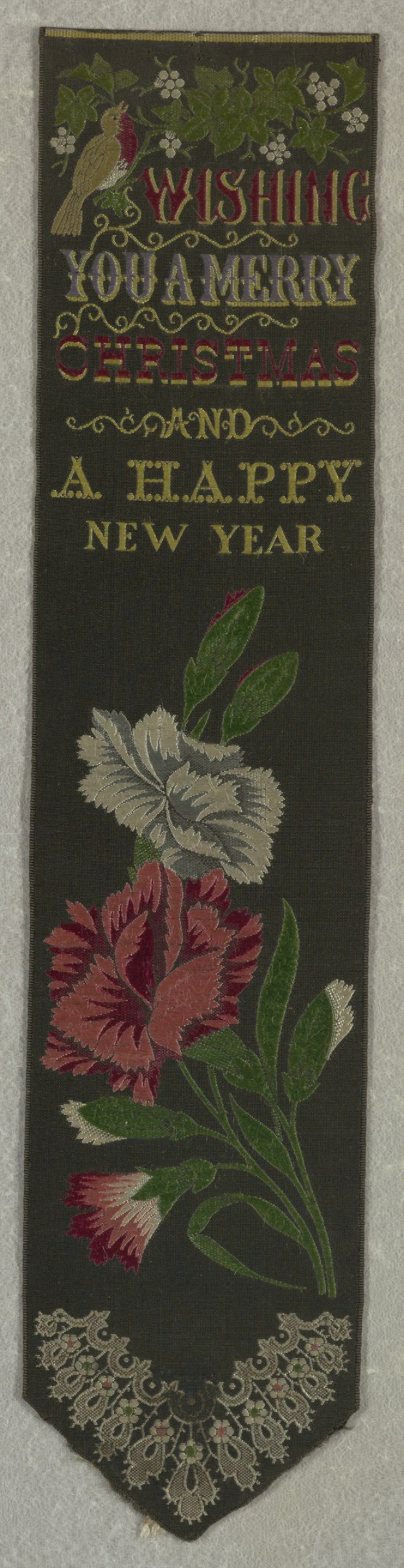 Ein schwarzes Banner mit einem roten und weißen Blumenmuster und der Aufschrift 'Frohe Weihnachten und ein gutes neues Jahr' bestickt, umgeben von bunten Blumen und Blättern.