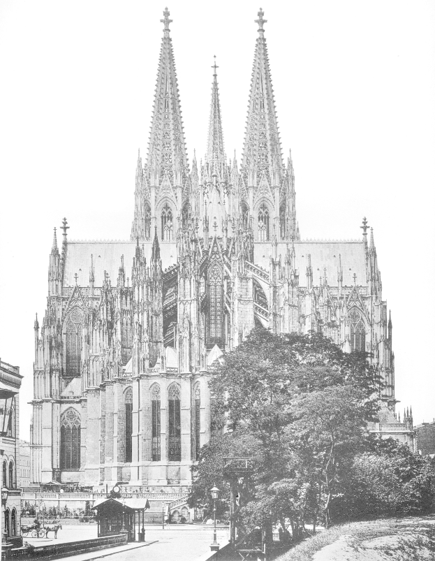 Ein Schwarz-Weiß-Foto der Kölner Kathedrale in Köln, Deutschland, ein majestätisches Gebäude mit hohen Türmen und detaillierten Verzierungen, umgeben von Bäumen, Straßenlaternen, Straßenlaternen und Menschen auf der Straße, mit dem Himmel im Hintergrund.